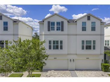 Charming two-story townhouse featuring a two-car garage, neutral color palette, and paver driveway at 3807 W Cleveland St, Tampa, FL 33609