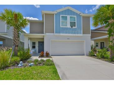 Charming two-story home with a well-manicured lawn, palm trees, and a two-car garage at 5438 Summer Sunset Dr, Apollo Beach, FL 33572