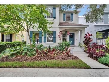 Charming home featuring a blue front door, shutters, and lush, colorful landscaping at 5918 Beaconpark St, Lithia, FL 33547
