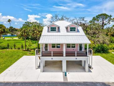 Charming raised home with a metal roof and a spacious ground-level parking and entertaining area at 6715 Wander Ln, New Port Richey, FL 34654