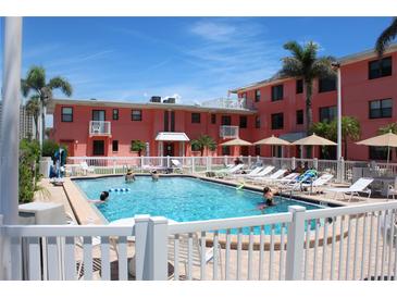 Inviting swimming pool surrounded by lounge chairs and lush landscaping, perfect for relaxation at 6800 Sunset Way # 1708, St Pete Beach, FL 33706