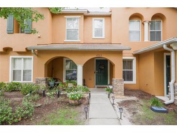 Charming townhome with front porch, archways, and green door in landscaped yard at 6925 Marble Fawn Pl, Riverview, FL 33578