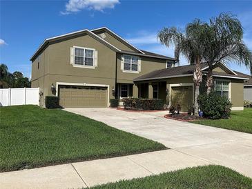 Two-story home with well-maintained lawn, desert landscaping, and a two-car garage plus a one-car garage at 20101 Oakflower Ave, Tampa, FL 33647