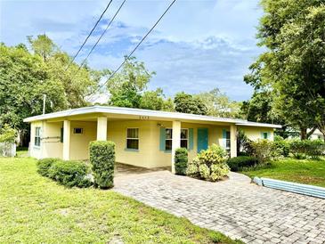 Charming single-story home featuring a brick driveway and inviting covered entrance with bright blue trim at 3575 Lake Highland Dr, Palm Harbor, FL 34683