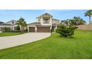 Charming two-story home with a large manicured front lawn, a three-car garage, and a second-story balcony at 4607 Los Robles Ct, Palmetto, FL 34221