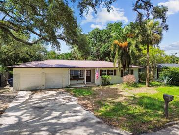Charming single-story home with a well-manicured lawn, mature trees, and a convenient two-car garage at 5107 W Azeele St, Tampa, FL 33609