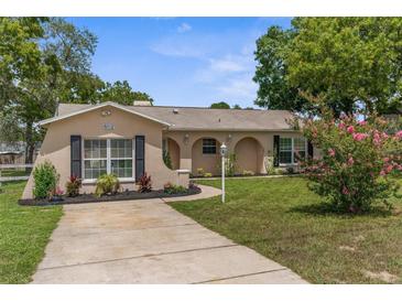 Charming single-story home with an arched entryway, landscaped front yard, and concrete driveway at 5112 Odin St, Spring Hill, FL 34608