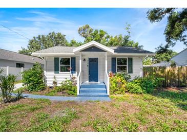 Charming single-story home with a blue front door, white siding, and lovely landscaping at 716 35Th W St, Bradenton, FL 34205