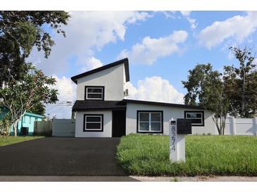 Modern two-story home showcasing a minimalist aesthetic with clean lines and a fresh, inviting black and white exterior at 8274 Rose Ter, Seminole, FL 33777