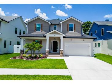 Charming two-story home featuring stone accents, a well-manicured lawn, and a two-car garage at 1015 W Charter St, Tampa, FL 33602