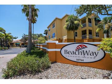 Sunny view of Beachway Condominiums community sign, surrounded by lush tropical landscaping at 10764 70Th Ave # 4305, Seminole, FL 33772