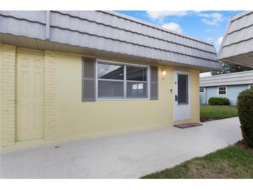 Charming condo featuring a neutral color scheme with matching door and a window with grey shutters at 201 Bedford St # 79, Sun City Center, FL 33573
