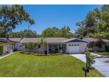 Charming single-story home with manicured lawn, tile roof, and attached garage at 2123 Indigo Dr, Clearwater, FL 33763