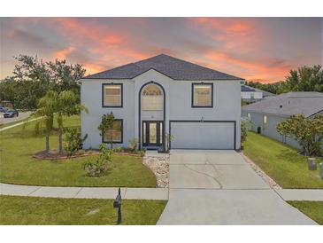 Charming two-story home with a well-manicured lawn and inviting curb appeal during a lovely sunset at 2746 Heathgate Way, Land O Lakes, FL 34638
