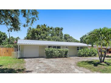Charming single-story home featuring a metal roof, attached garage, and mature landscaping in a residential neighborhood at 675 69Th S Ave, St Petersburg, FL 33712