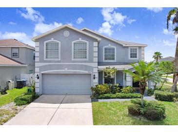 Charming two-story home with a well-maintained lawn, complemented by a paved driveway and lush landscaping at 7515 Dragon Fly Loop, Gibsonton, FL 33534