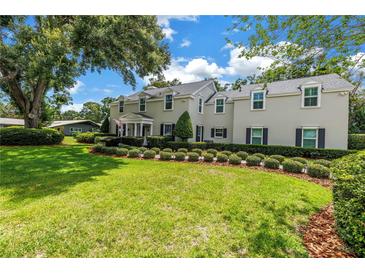 Charming two-story home with manicured lawn, lush green landscaping, and inviting curb appeal at 1628 Long Bow Ln, Clearwater, FL 33764
