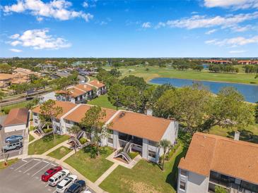 Scenic aerial view of condo community overlooking golf course and lake under a blue sky at 2049 Skimmer W Ct # 311, Clearwater, FL 33762