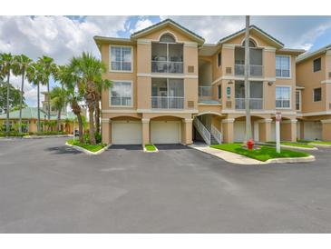 Beautiful building exterior featuring multiple garages, screened patios, and professional landscaping at 2201 Bay Club Cir, Tampa, FL 33607