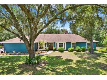 Charming single-story home with blue siding and mature landscaping under the shade of large trees at 2515 Pemberton Creek Dr, Seffner, FL 33584