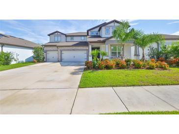 Charming two-story home with a three-car garage, a lush lawn, and vibrant landscaping at 2866 Quail Crest Ct, Valrico, FL 33594