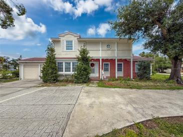 Charming two-story home featuring a brick facade, a balcony, a well-maintained lawn, and a large driveway at 425 49Th N St, St Petersburg, FL 33710