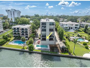 Modern condo complex with a pool overlooking the water and lush landscaping at 602 Lime Ave # 102, Clearwater, FL 33756