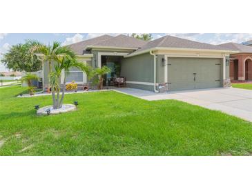 Well-manicured lawn complements this charming home, complete with a two-car garage and inviting front entryway at 11913 Butler Woods Cir, Riverview, FL 33579