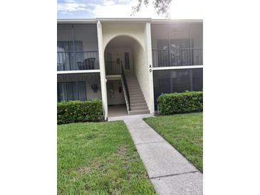 Charming condo featuring a private screened-in porch, lush landscaping, and well-maintained grounds at 1400 Pine Glen Ln # D2, Tarpon Springs, FL 34688