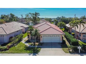 Well-maintained single-Gathering home with a red tile roof, neat landscaping, and attached two-car garage at 4415 Muirfiled Dr, Bradenton, FL 34210