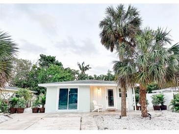 Charming single-story home with palm trees and a white gravel yard creating an inviting curb appeal at 690 Fox St, Longboat Key, FL 34228