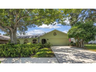 Charming single-story home with a well-manicured lawn and mature trees providing shade at 11250 Tradewinds Blvd, Largo, FL 33773