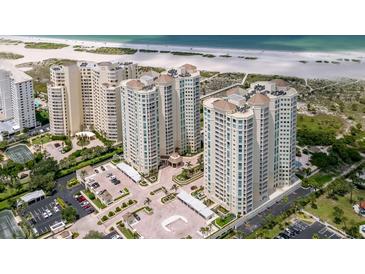 Stunning aerial view of beachfront condo buildings, lush landscaping, and beach access at 1180 Gulf Blvd # 504, Clearwater Beach, FL 33767