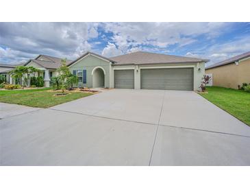 Charming single-story home with a well-manicured lawn and a spacious three-car garage at 13527 Willow Bluestar Loop, Riverview, FL 33579