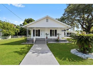 Charming single-story home with a well-manicured lawn and inviting front porch, perfect for relaxing outdoors at 4112 E Ellicott St, Tampa, FL 33610