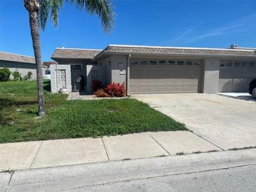Charming single-story home featuring an attached garage and landscaping at 587 Boca Ciega Point N Blvd, St Petersburg, FL 33708