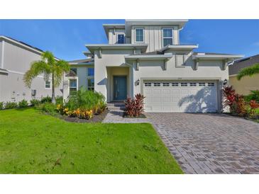 Charming two-story home with manicured lawn, beautiful landscaping, and a paver driveway at 955 Signet Dr, Apollo Beach, FL 33572