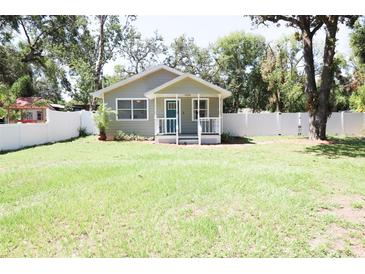 Charming single-story home featuring a well-maintained lawn and inviting front porch at 1103 E Lambright St, Tampa, FL 33604