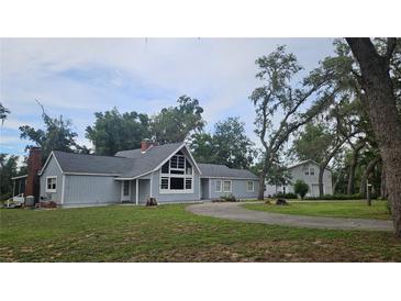 Charming home boasts a well-maintained yard, mature trees, complementing the property's inviting exterior and curb appeal at 21451 Us Highway 98, Dade City, FL 33523