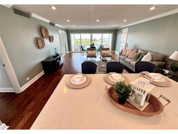 Bright living room features an open floor plan, hardwood floors, and stunning water views from a large window at 1365 Snell Isle Ne Blvd # 6E, St Petersburg, FL 33704