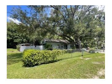 Charming single story home with mature landscaping and a chain-link fence at 14935 Ogden Loop, Odessa, FL 33556