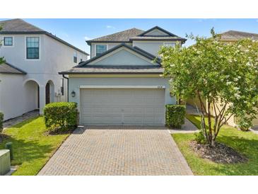 Charming two-story home with a two-car garage, brick driveway, and well-maintained landscaping at 1604 Acadia Harbor Pl, Brandon, FL 33511