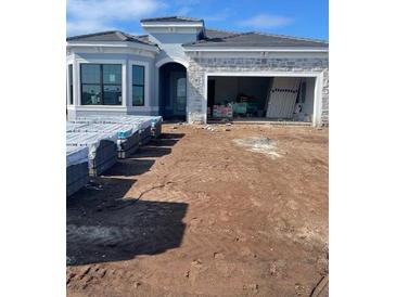 New construction single-Gathering home featuring stone accents, a modern design, and an attached two-car garage at 19422 Indian Rock Pl, Lakewood Ranch, FL 34211