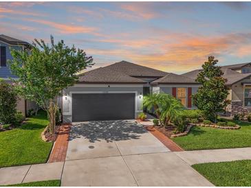Charming single-Gathering home features a well-manicured lawn and a two-car garage at 11745 Brighton Knoll Loop, Riverview, FL 33579