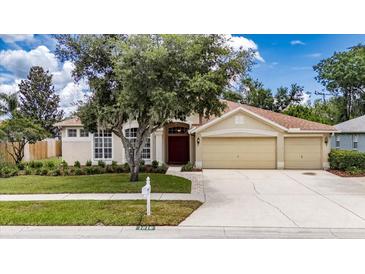 Charming single-Gathering home featuring a well-manicured lawn and a spacious three-car garage at 1216 Fox Chapel Dr, Lutz, FL 33549