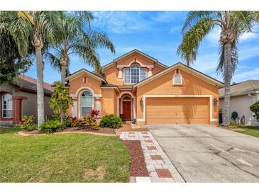 Charming two-story home featuring mature landscaping and a welcoming front entrance at 31241 Kirkshire Ct, Wesley Chapel, FL 33543