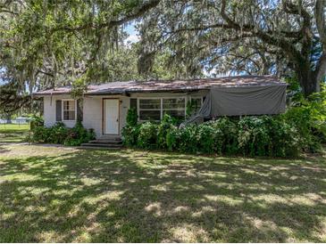 Charming single-story home featuring a cozy front porch and lush, mature landscaping at 4205 Old Mulberry Rd, Plant City, FL 33567