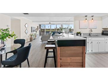 Bright open kitchen with a breakfast bar, stainless steel appliances, and views of the living area and outside at 450 Treasure Isle Causeway # 212, Treasure Island, FL 33706