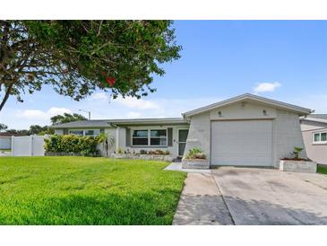 Charming single-story home featuring a well-manicured lawn and attached garage, perfect for comfortable living at 5720 Mockingbird Dr, New Port Richey, FL 34652