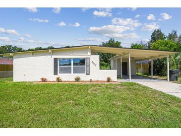 Charming single-story home with a covered carport, neat landscaping, and freshly cut green grass at 2017 Waikiki Way, Tampa, FL 33619